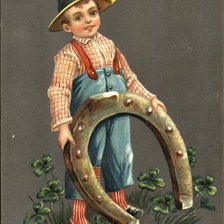 Boy with floppy hat is holding a large horseshoe